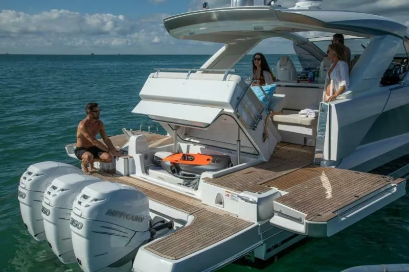 Slide: The Image of 2024 Jeanneau DB43 yacht with people enjoying the deck and ocean view. - 3