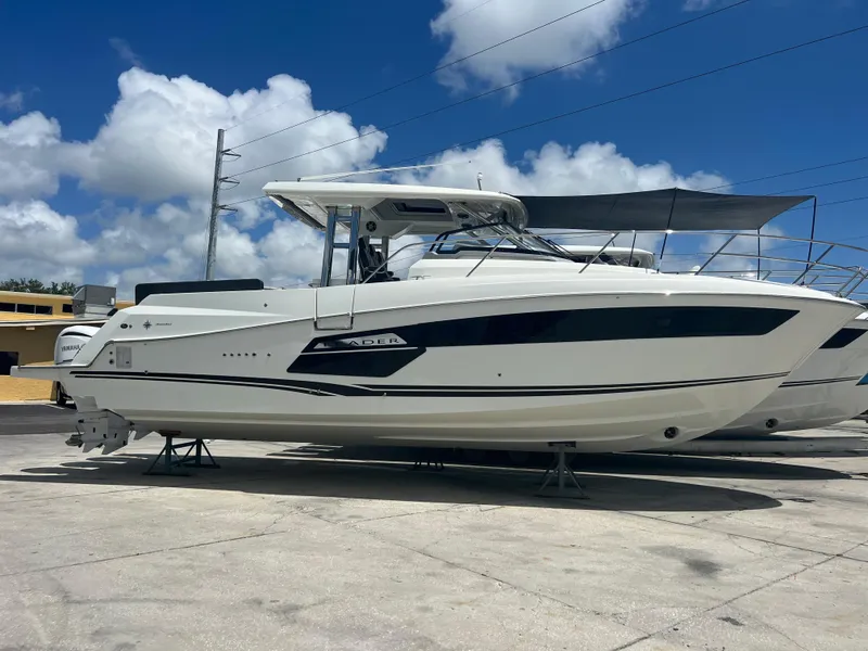Slide: The Image of 2024 Jeanneau 12.5 Walk boat docked under clear blue sky. - 1