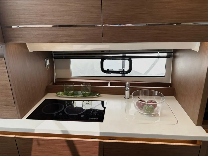 Slide: The Image of 2024 Jeanneau 12.5 Walk boat with luxurious seating at a marina. - 18