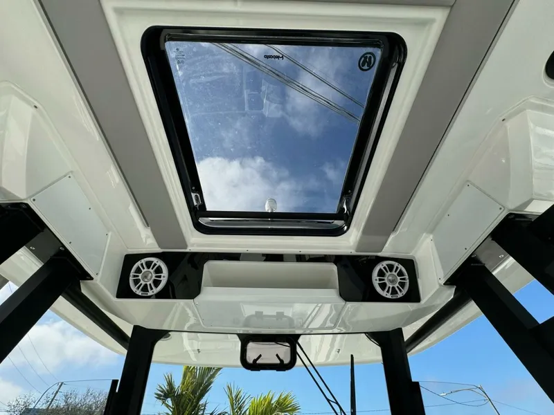 Slide: The Image of 2024 Jeanneau 10.5 CC boat interior with skylight and speakers, showcasing modern design. - 12