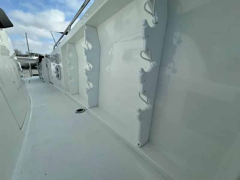 Slide: The Image of 2024 Jeanneau 10.5 CC boat deck with rod holders and clean white finish. - 13