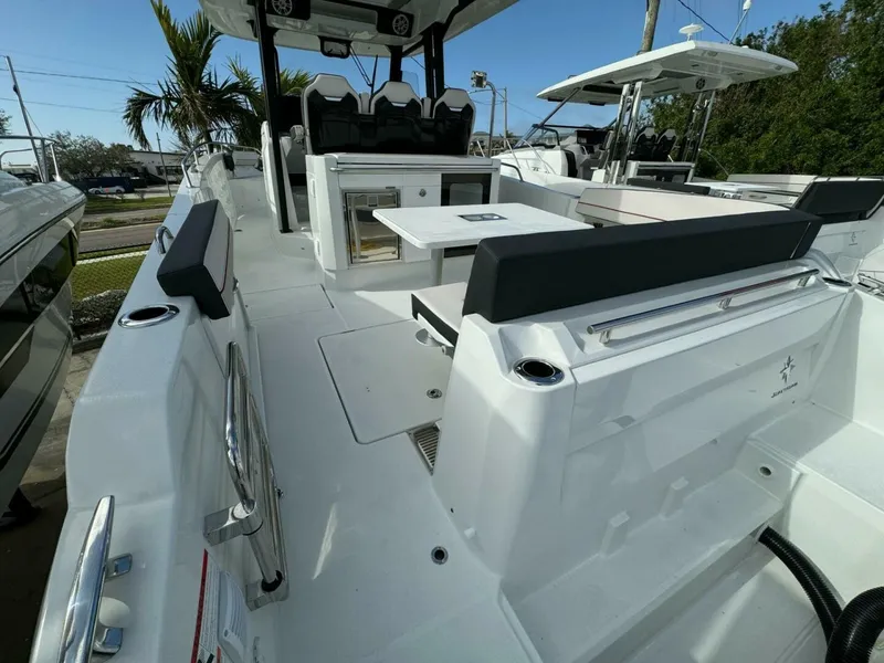 Slide: The Image of 2024 Jeanneau 10.5 CC boat interior with seating and table, showcasing modern design. - 2