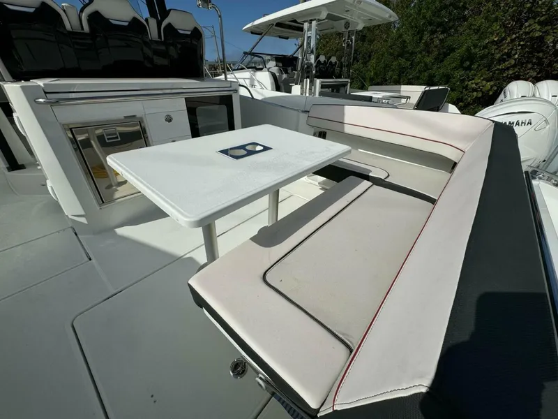 Slide: The Image of 2024 Jeanneau 10.5 CC boat interior with seating and table setup. - 3