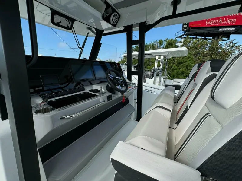 Slide: The Image of 2024 Jeanneau 10.5 CC boat interior with modern dashboard and seating. - 6