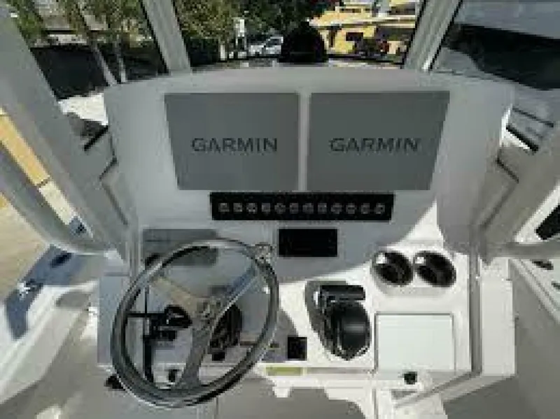Slide: The Image of 2025 Regulator 24 XO boat dashboard with dual Garmin displays and steering wheel. - 4
