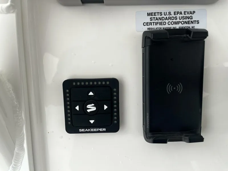Slide: The Image of Control panel and wireless charger on 2025 Regulator 30XO boat, meeting EPA standards. - 15