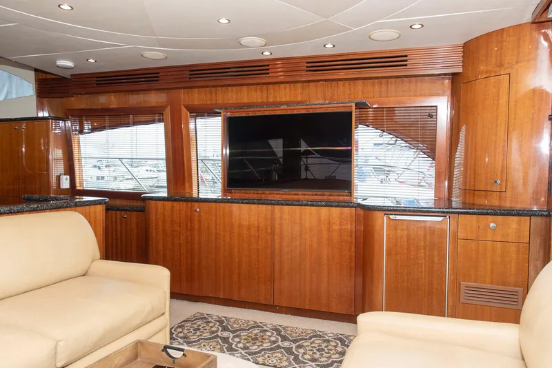 Slide: The Image of Luxurious interior of 2002 Hatteras 63 Raised Pilothouse Motor Yacht with wood paneling and TV. - 10
