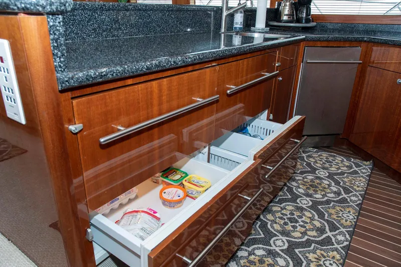 Slide: The Image of Kitchen area of 2002 Hatteras 63 Yacht with open drawers and granite countertop. - 15