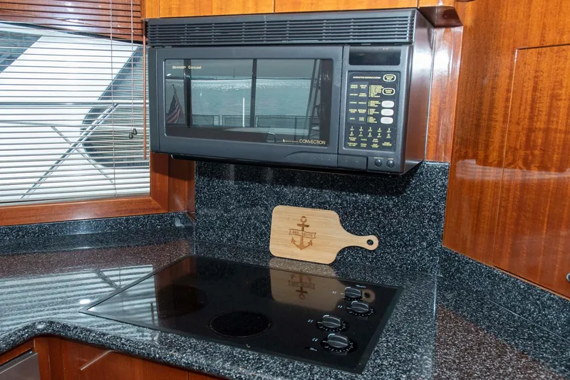 Slide: The Image of Kitchen area of 2002 Hatteras 63 Yacht with microwave and stovetop. - 20