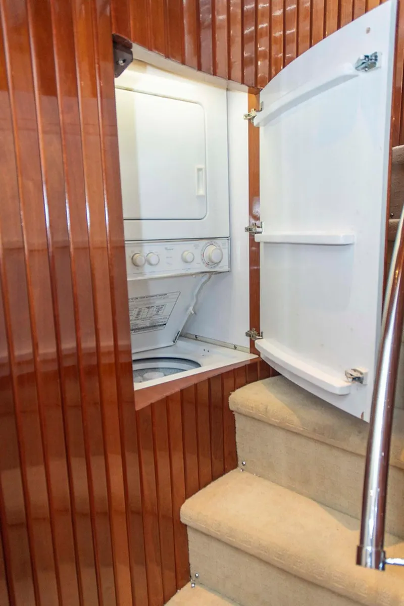 Slide: The Image of Laundry area inside 2002 Hatteras 63 Raised Pilothouse Motor Yacht, featuring stacked washer and dryer. - 38