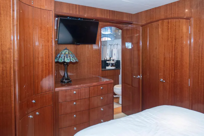 Slide: The Image of Luxurious wood-paneled bedroom in 2002 Hatteras 63 Motor Yacht with TV and ensuite bathroom. - 43