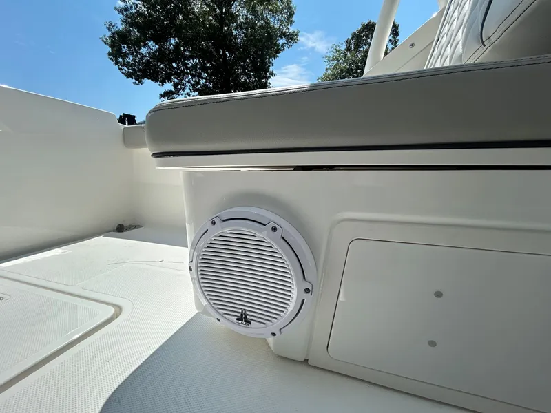 Slide: The Image of 2026 Pursuit DC 246 Dual Console boat interior with speaker and seating, under clear blue sky. - 11
