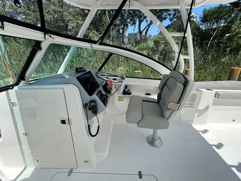 Slide: The Image of 2026 Pursuit DC 246 Dual Console boat interior with helm and seating. - 13