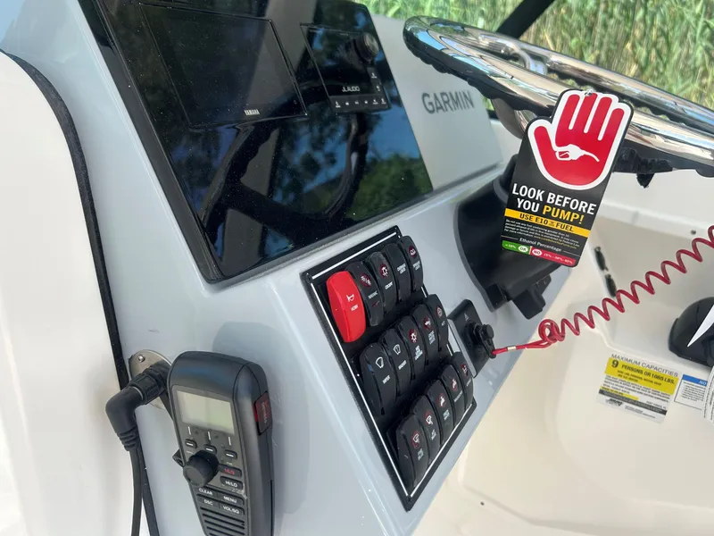 Slide: The Image of Control panel of 2026 Pursuit DC 246 Dual Console boat with Garmin display and safety warning. - 17