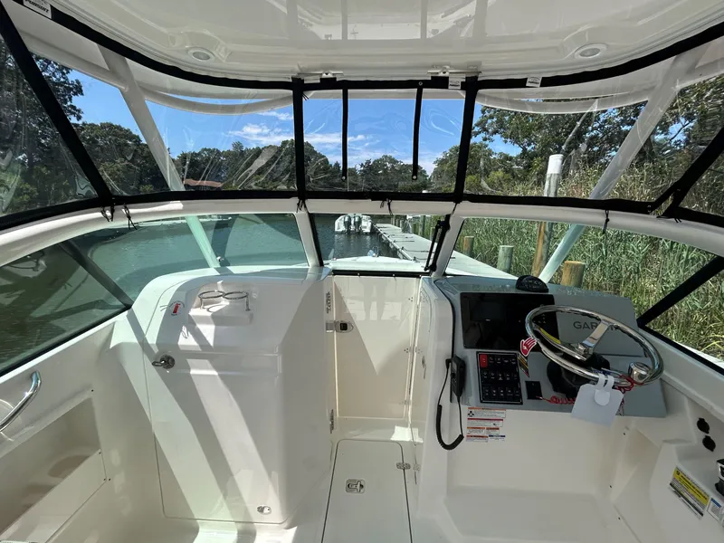 Slide: The Image of 2026 Pursuit DC 246 Dual Console boat interior with steering wheel and dashboard view. - 19