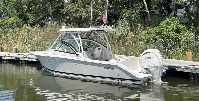 Slide: The Image of 2026 Pursuit DC 246 Dual Console boat docked with Yamaha engine. - 2