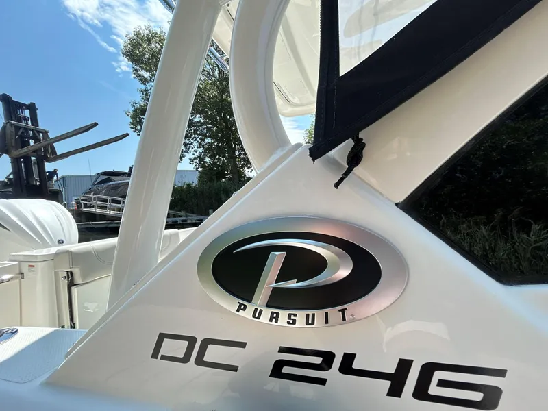 Slide: The Image of 2026 Pursuit DC 246 Dual Console boat with logo, sunny day, outdoor setting. - 22