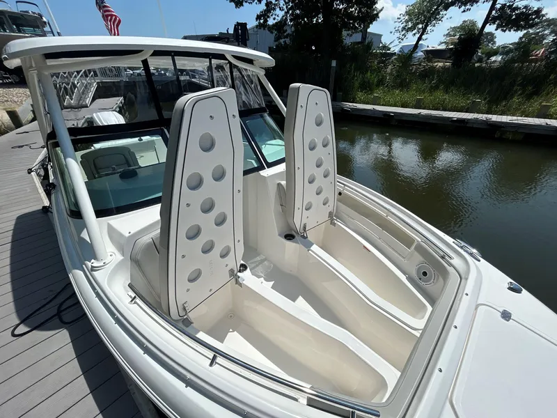 Slide: The Image of 2026 Pursuit DC 246 Dual Console boat docked, featuring spacious seating and sleek design. - 26