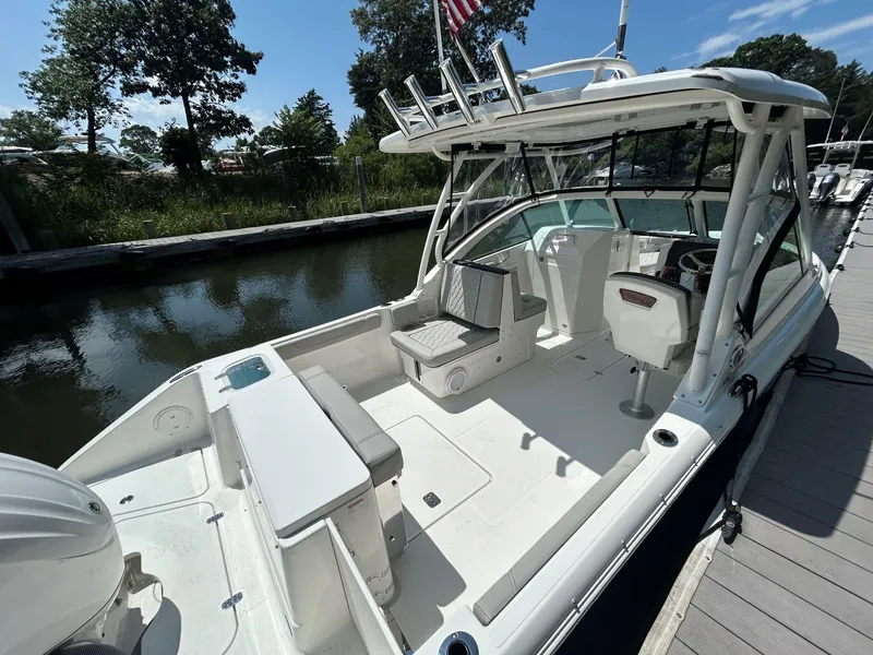 Slide: The Image of 2026 Pursuit DC 246 Dual Console boat docked, showcasing spacious seating and sleek design. - 4