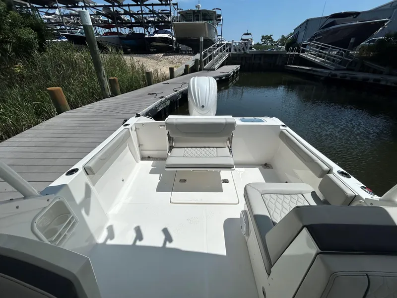 Slide: The Image of 2026 Pursuit DC 246 Dual Console boat docked, featuring spacious seating and sleek design. - 6