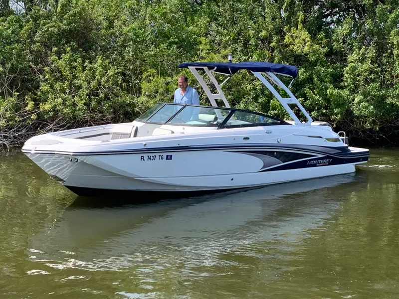 The Image of 2021 Monterey M6 boat on calm water, surrounded by lush greenery. - 0
