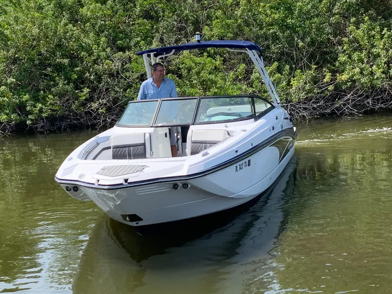 Slide: The Image of 2021 Monterey M6 boat cruising on a calm river with lush greenery. - 1
