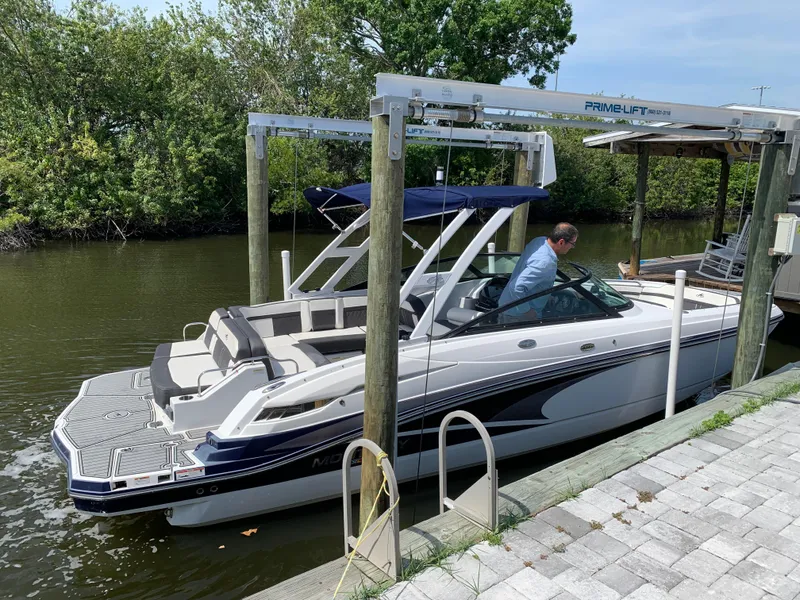 Slide: The Image of 2021 Monterey M6 boat docked at a marina with a person onboard. - 2