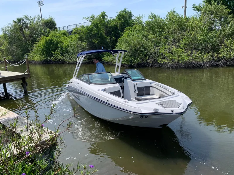 Slide: The Image of 2021 Monterey M6 boat navigating a narrow waterway near lush greenery. - 3