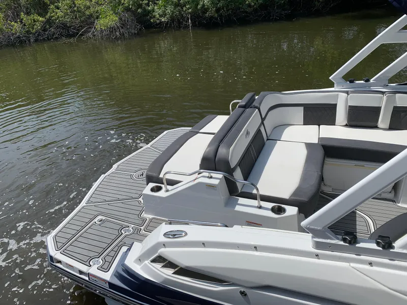 Slide: The Image of 2021 Monterey M6 boat with sleek seating and swim platform on calm water. - 7