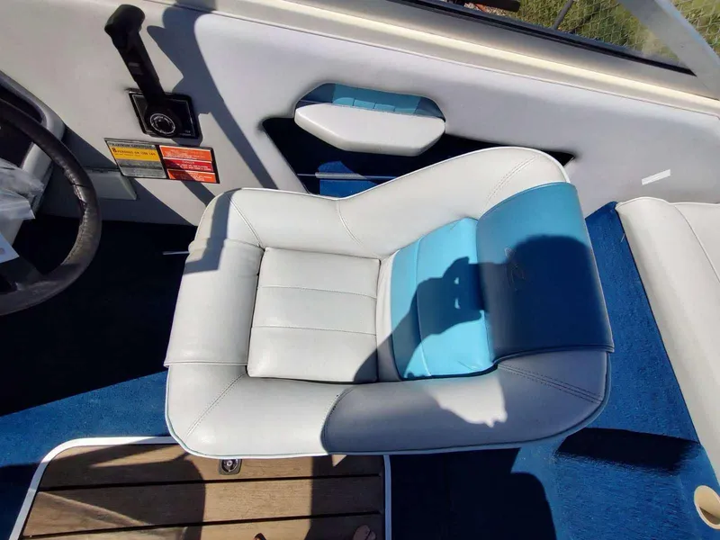 Slide: The Image of Captain's seat on 1988 Sea Ray 230 Bow Rider Select boat, featuring blue and white upholstery. - 10