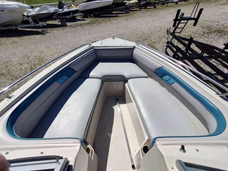 Slide: The Image of 1988 Sea Ray 230 Bow Rider Select with spacious seating in a boatyard. - 11