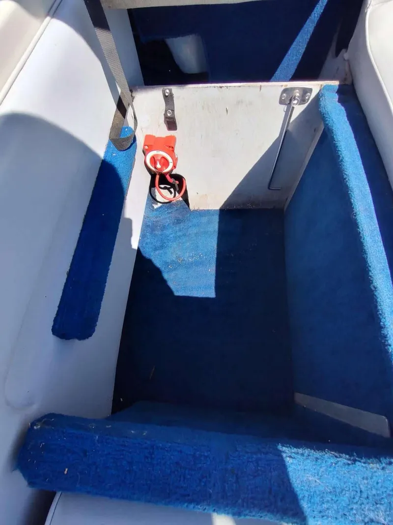 Slide: The Image of Interior of 1988 Sea Ray 230 Bow Rider Select with blue carpet and storage compartment. - 14