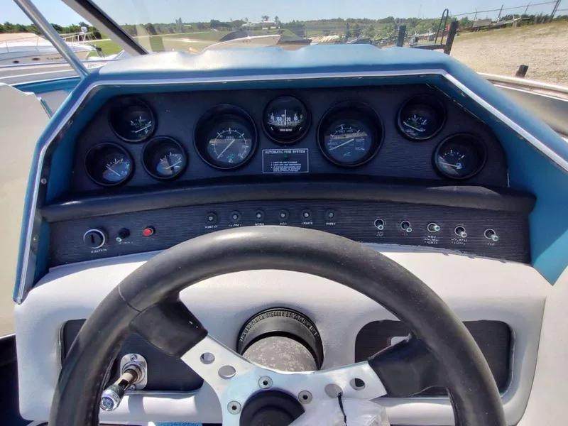 Slide: The Image of 1988 Sea Ray 230 Bow Rider Select dashboard with gauges and steering wheel. - 16