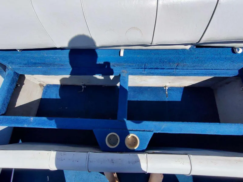 Slide: The Image of 1988 Sea Ray 230 Bow Rider Select interior with blue carpet and cup holders. - 8