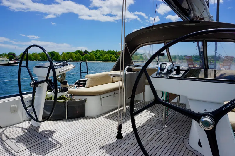 Slide: The Image of 2020 Beneteau First 53 yacht cockpit with dual steering wheels and scenic water view. - 10
