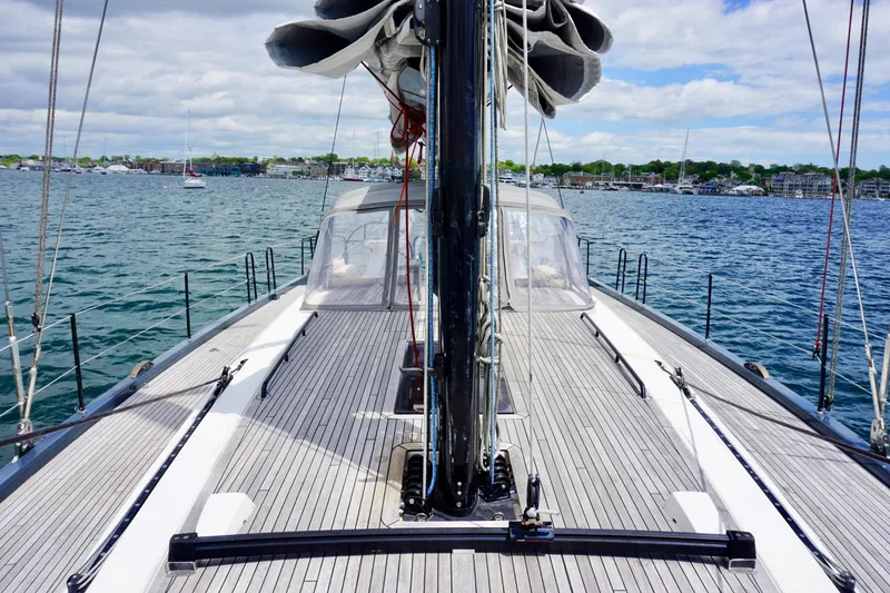 Slide: The Image of 2020 Beneteau First 53 sailboat deck view, moored on calm waters under a partly cloudy sky. - 18