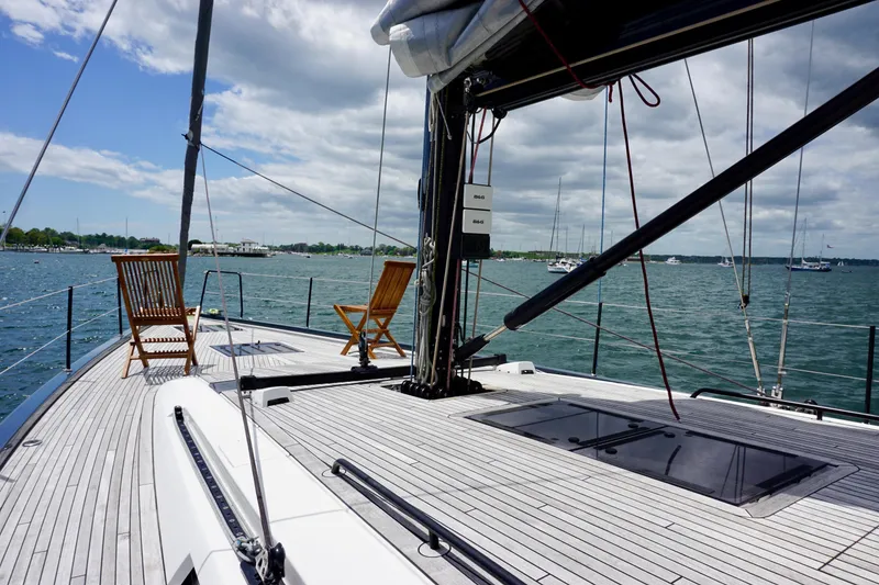 Slide: The Image of 2020 Beneteau First 53 yacht deck with chairs, overlooking a serene sea view. - 20