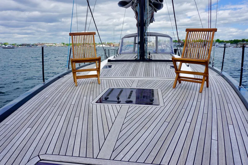 Slide: The Image of Deck of 2020 Beneteau First 53 sailboat with wooden chairs, on calm water. - 24