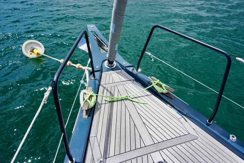 Slide: The Image of Bow of 2020 Beneteau First 53 sailboat with teak deck on water. - 25