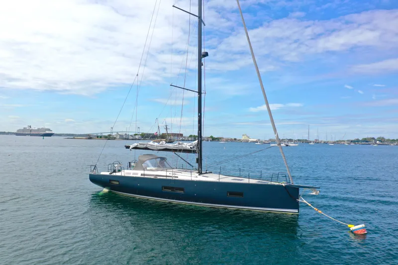 Slide: The Image of 2020 Beneteau First 53 sailboat anchored in a scenic harbor. - 4
