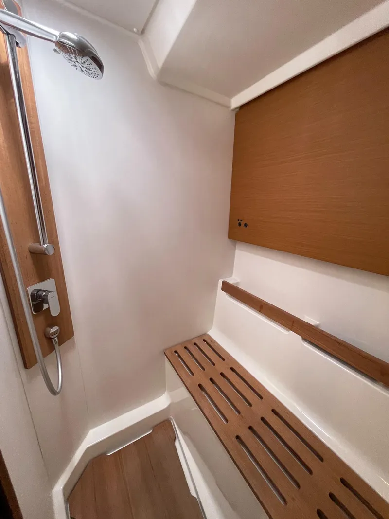 Slide: The Image of Beneteau First 53 2020 yacht shower with wooden bench and modern fixtures. - 48