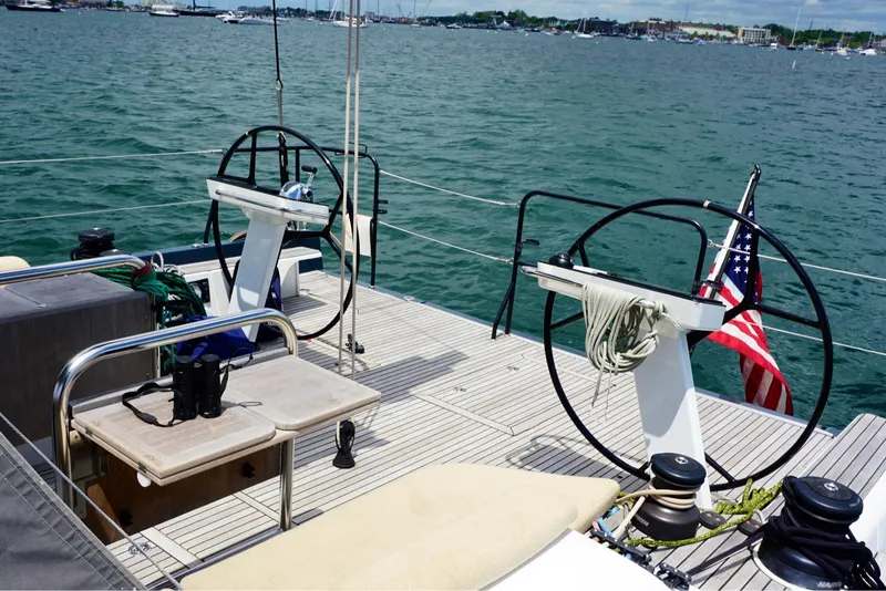 Slide: The Image of Beneteau First 53 sailboat deck, dual steering wheels, American flag, ocean view, 2020 model. - 9