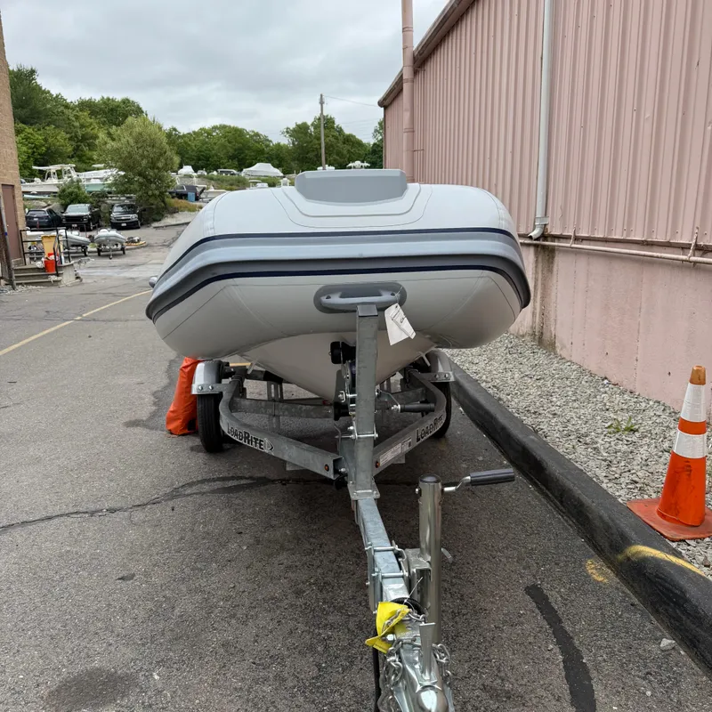 Slide: The Image of 2024 Highfield CL340 boat on trailer near a building, ready for transport. - 2