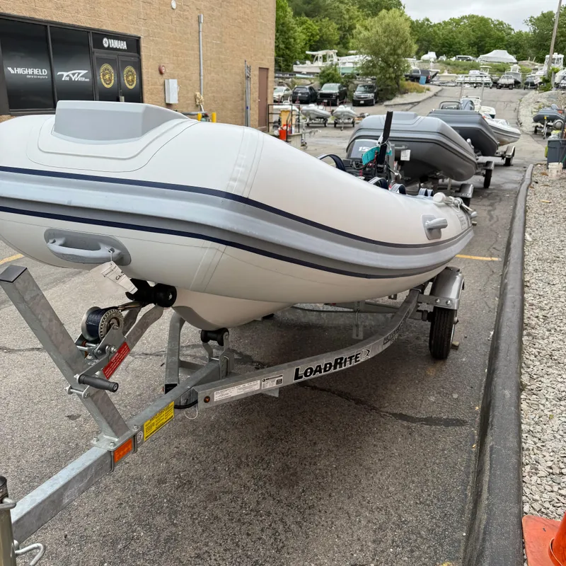 Slide: The Image of 2024 Highfield CL340 inflatable boat on Load Rite trailer in a parking lot. - 3