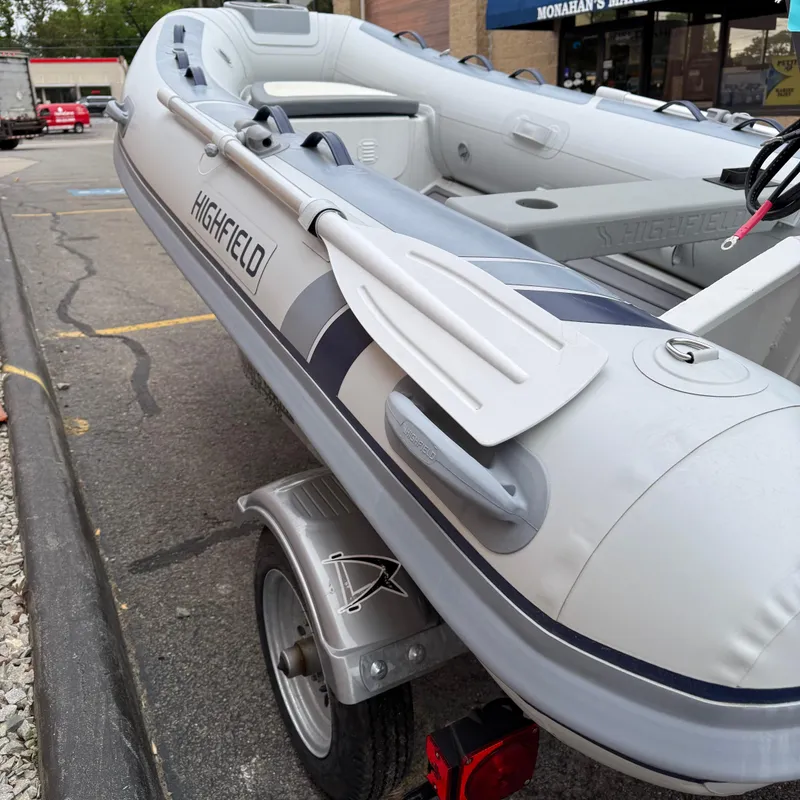Slide: The Image of 2024 Highfield CL340 inflatable boat on trailer, parked in urban setting. - 9