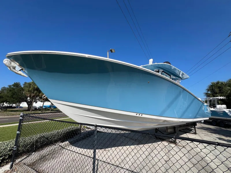 Slide: The Image of 2025 Sportsman 352 Open boat in vibrant blue, displayed outdoors on a sunny day. - 1