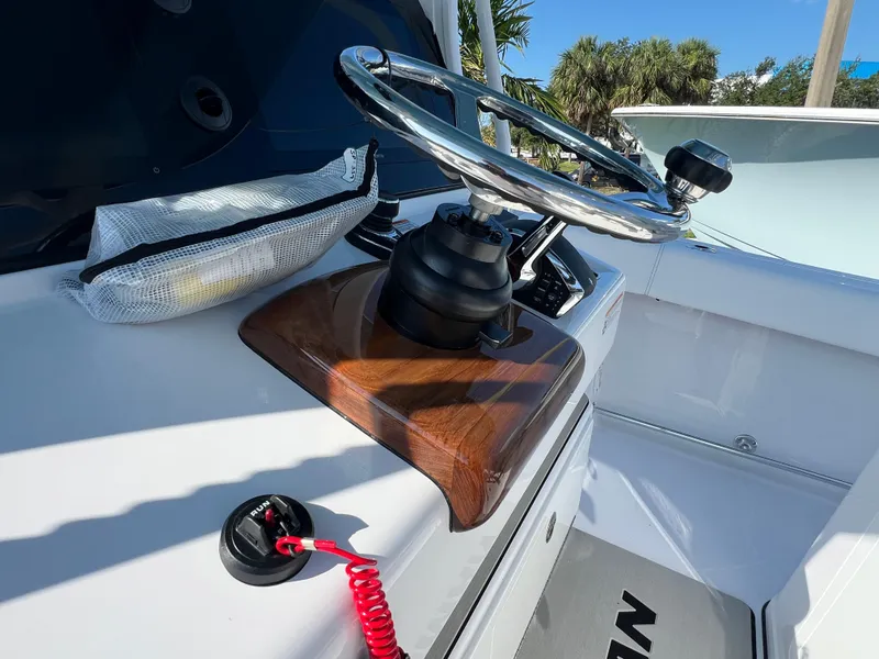 Slide: The Image of Steering wheel of 2025 Sportsman 352 Open boat with wooden accents and control panel. - 32