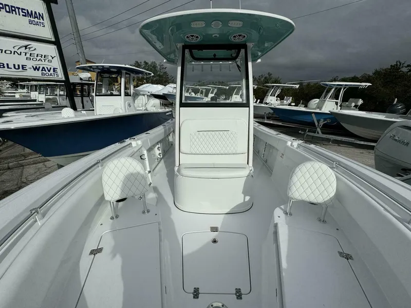 Slide: The Image of 2025 Sportsman 232 Open boat interior with white seating and console, displayed at a dealership. - 13
