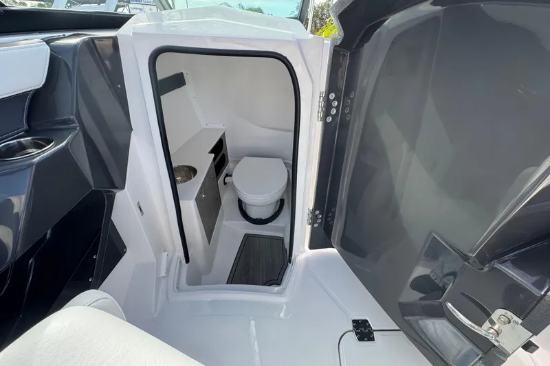 Slide: The Image of Interior of 2025 Monterey M-255 boat featuring a compact bathroom with toilet and sink. - 14