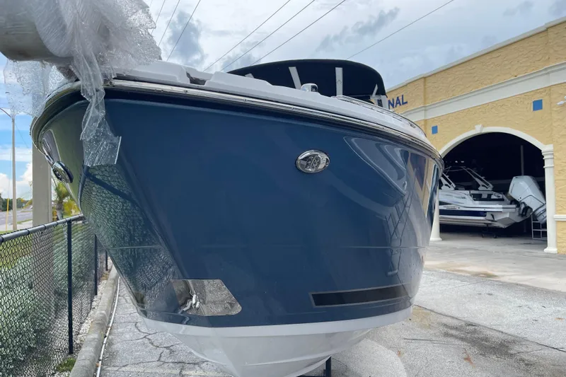 Slide: The Image of 2025 Monterey M-255 boat in front of a showroom, wrapped in protective material. - 2